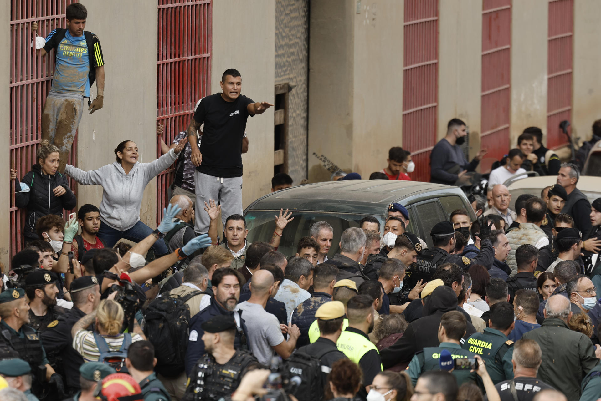 El rey Felipe rodeado por vecinos indignados, durante su visita a Paiporta este domingo, epicentro de las inundaciones de Valencia. Gritos de "fuera", así como lanzamiento de barro, recibieron a la comitiva de los reyes de España, el presidente del Gobierno, Pedro Sánchez, y el presidente regional de Valencia, Carlos Mazón. EFE/Biel Aliño