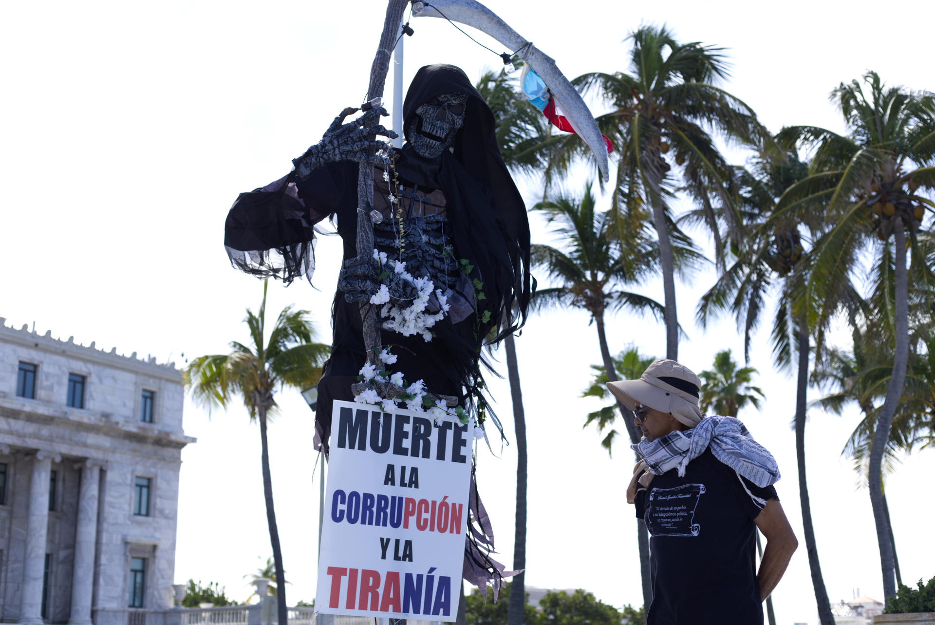 Fotografía del 25 de octubre de 2024 del activista Tito Kayak mirando a un cartel que dice "Muerte a la corrupción y a la tiranía", en San Juan (Puerto Rico). EFE/ Thais Llora