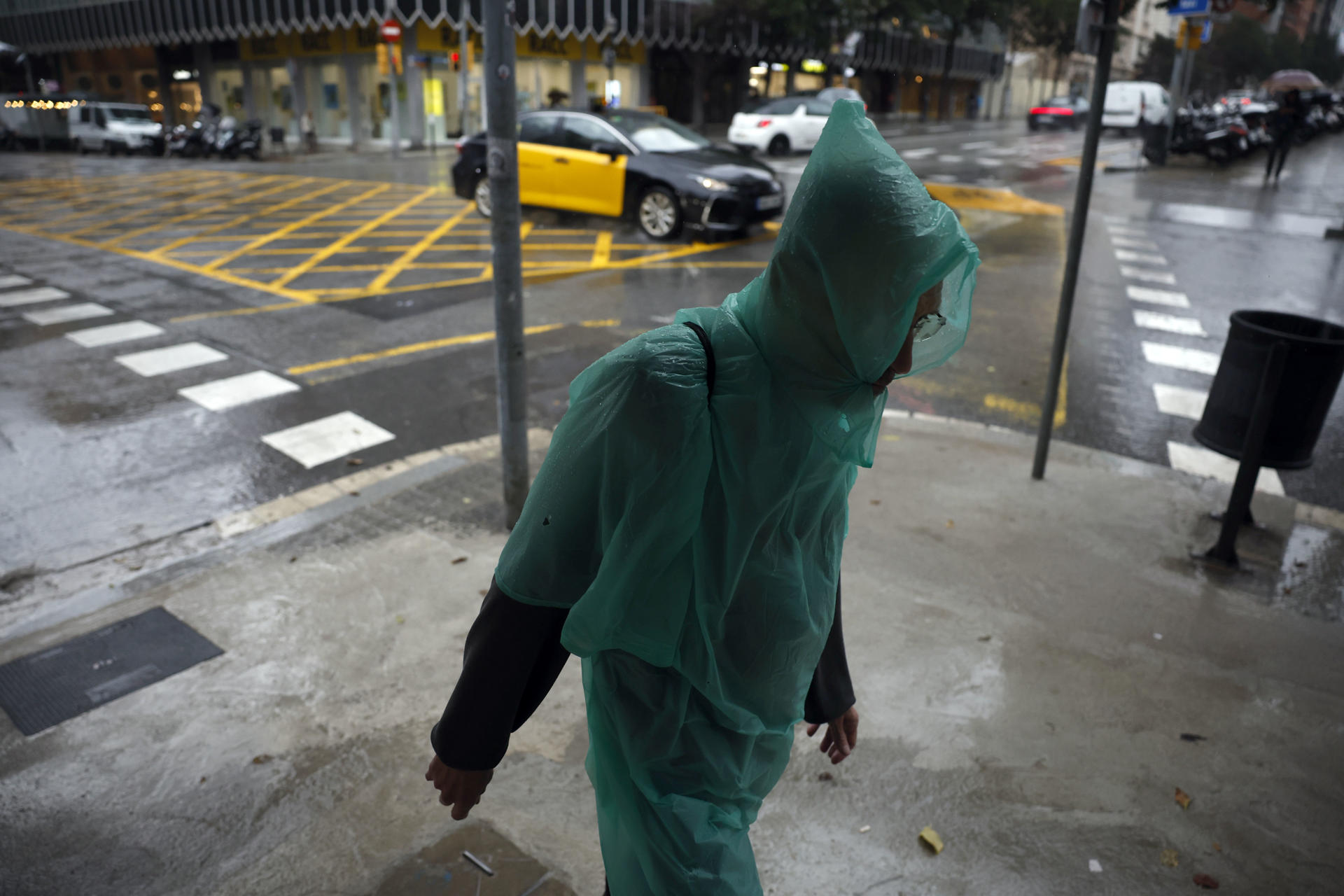 Un hombre camina bajo la lluvia por el centro de Barcelona este lunes cuando las comarcas de del Garraf y del Barcelonès, en Barcelona, están en aviso rojo de la Agencia Estatal de Meteorología (Aemet), y la Generalitat ha enviado una alerta a los teléfonos móviles por la llegada de lluvias continuadas y torrenciales. EFE/Alberto Estévez

