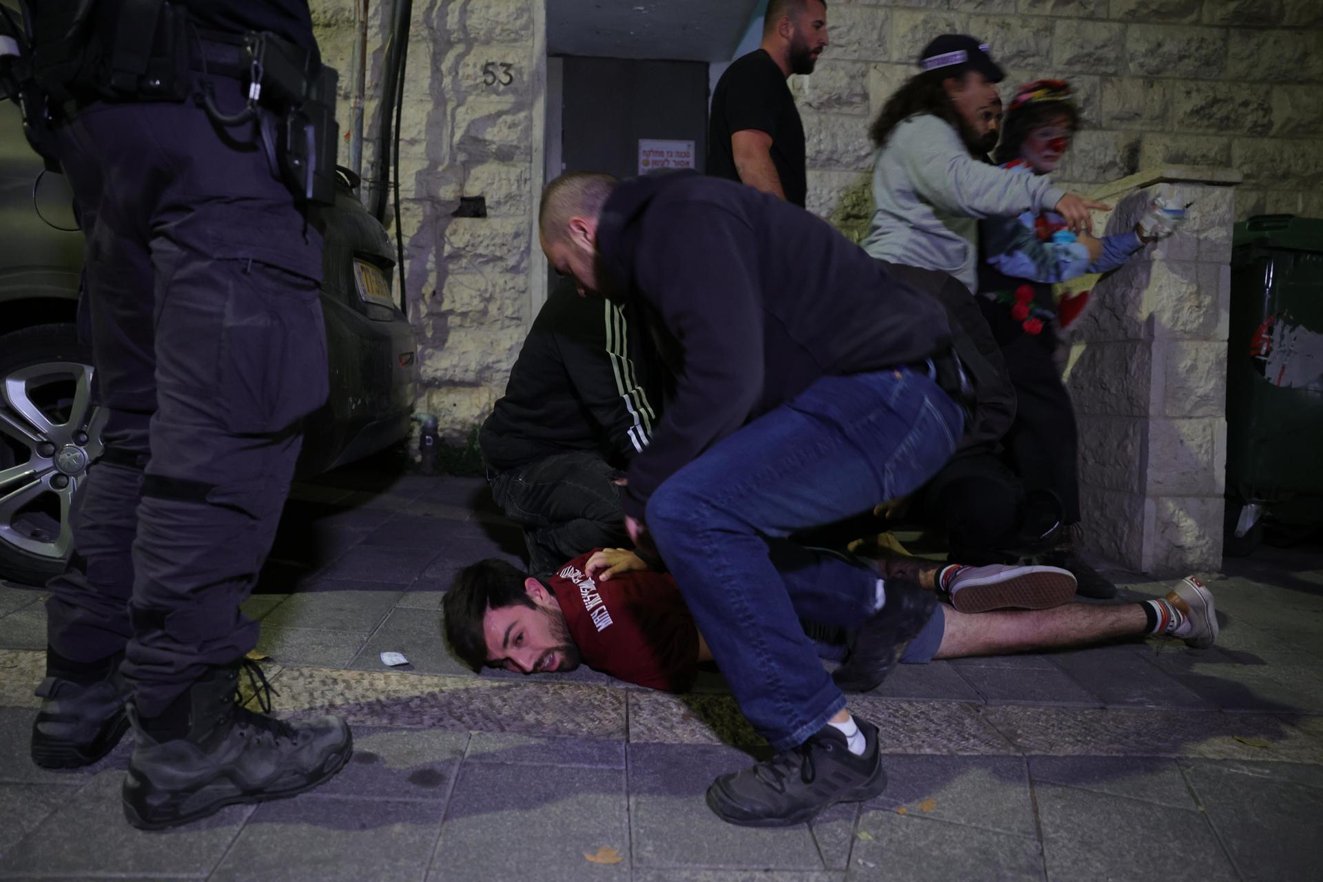 La policía arresta a una persona mientras manifestantes antigubernamentales salen a las calles después de que el primer ministro israelí anunciara que había despedido al ministro de Defensa, Yoav Gallant, frente a la residencia del primer ministro en Jerusalén. EFE/EPA/ABIR SULTAN
