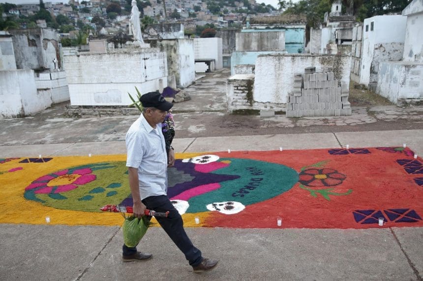 Un hombre camina al Cementerio General donde pondrá flores a un familiar fallecido, en el marco de Día de Muertos, este sábado de la ciudad de Comayagüela (Honduras). EFE/Gustavo Amador
