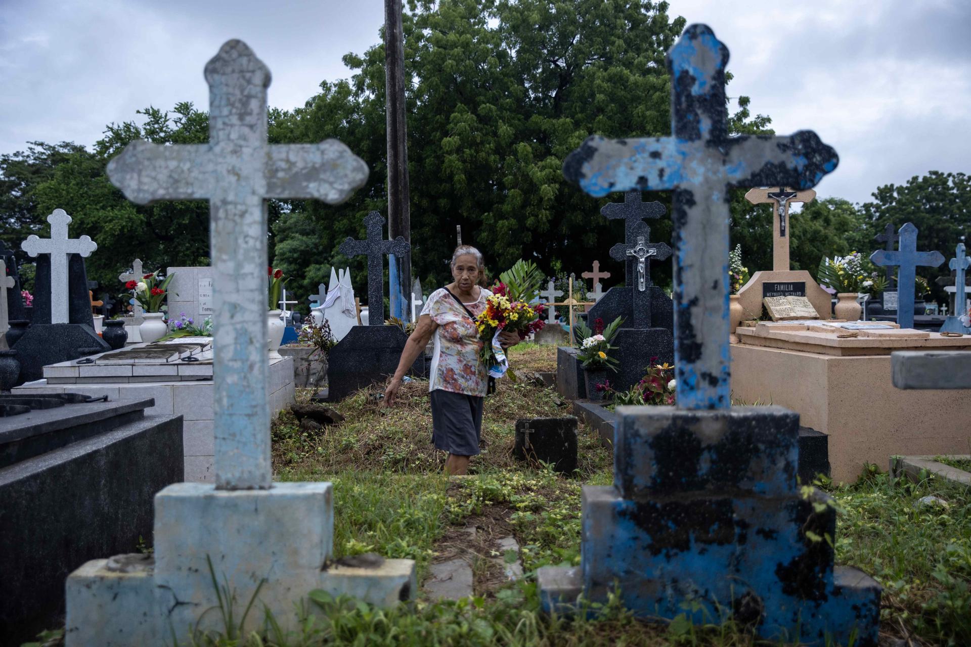 Una mujer visita la tumba de un familiar, en el marco de Día de Muertos, este sábado en un cementerio de Managua (Nicaragua). EFE/Stringer
