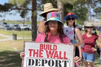 Fotografía de archivo de una mujer con un cartel antimingrantes durante un evento de campaña de Donald Trump. EFE/ Ana Milena Varon