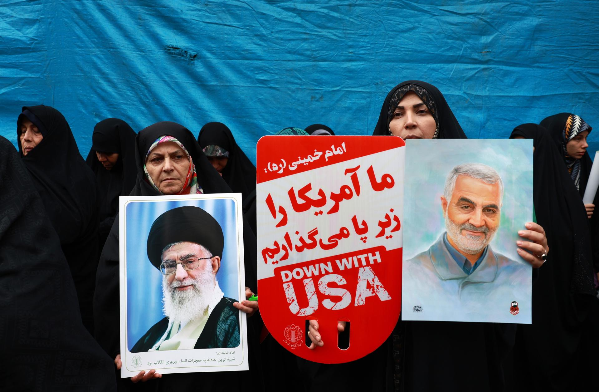 Mujeres iraníes con fotografías del líder supremo iraní, el ayatolá Ali Jamenei, y del asesinado excomandante de las fuerzas Quds de la IRGC, Qasem Soleimani, mientras participan en una manifestación antiestadounidense que conmemora el 45 aniversario de la toma de la embajada de EE. UU., frente al antiguo edificio de la legación diplomática en Teherán, el 3 de noviembre de 2024. EFE/EPA/ABEDIN TAHERKENAREH
