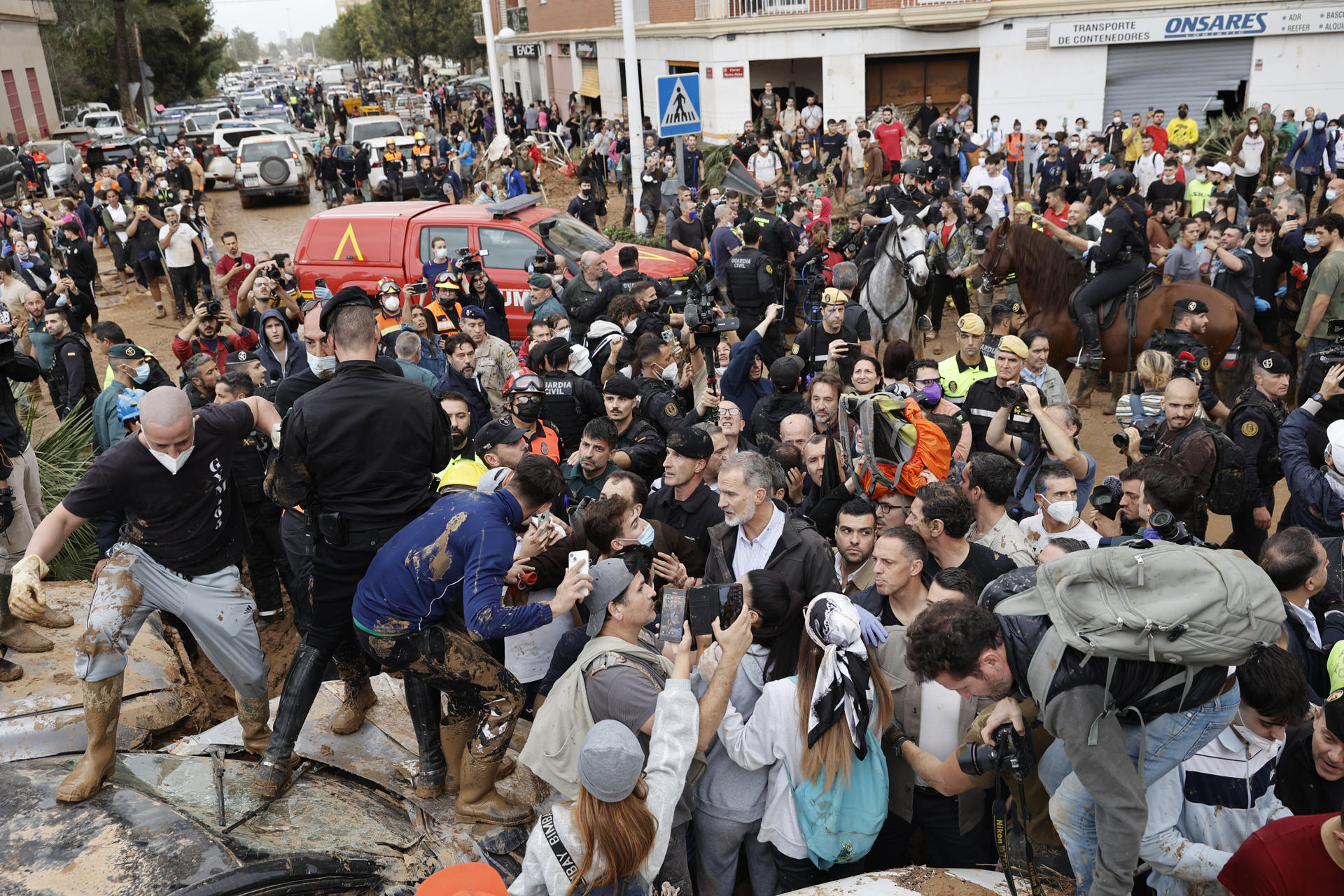 El rey Felipe VI trata de calmar a los vecinos indignados, durante su visita este domingo a Paiporta, epicentro de las inundaciones de Valencia, donde los reyes, el presidente del Gobierno, Pedro Sánchez, y el presidente regional de Valencia, Carlos Manzón, fueron recibidos con gritos de 'fuera', así como lanzamiento de barro. EFE/Biel Aliño
