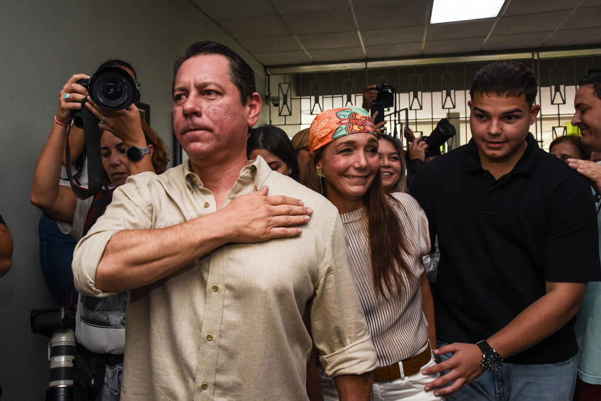 El candidato a la gobernación de Puerto Rico por la Alianza formada por el Partido Independentista Puertorriqueño (PIP) y el Movimiento Victoria Ciudadana (MVC), Juan Dalmau, saluda junto a su esposa (c) y su hijo, a su llegada este martes a depositar su voto en el Centro Cedin, en San Juan (Puerto Rico). EFE/Enid M. Salgado
