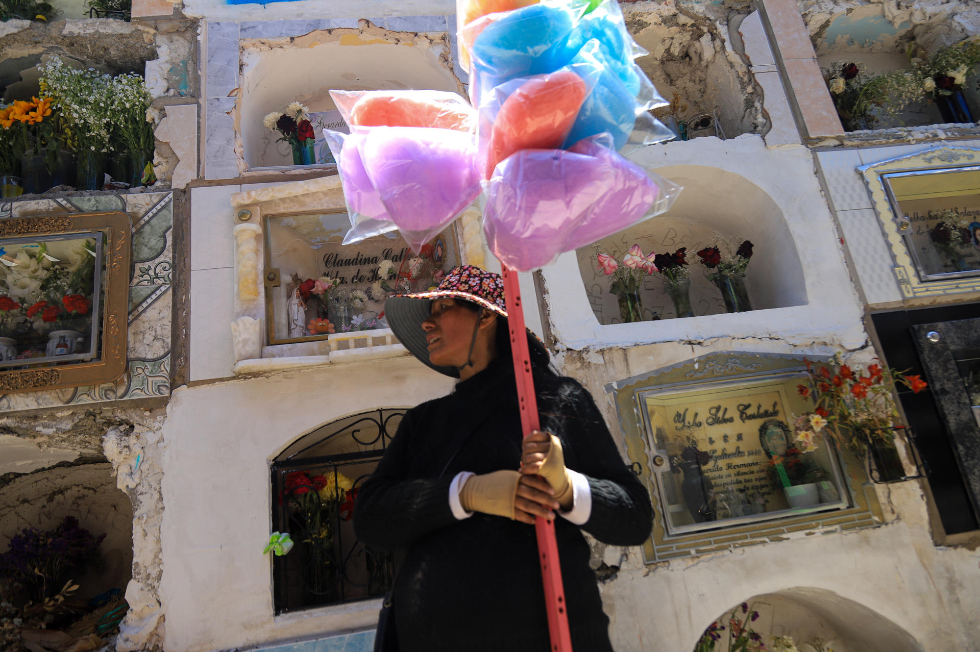 Una boliviana con algodones de azúcar visita el cementerio general este 2 de noviembre de 2024, en la ciudad de La Paz (Bolivia).EFE/ Gabriel Márquez
