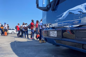 Fotografía de archivo en donde se ven migrantes que esperan para tomar un bus en EE.UU. EFE/ Alex Segura