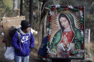 Una persona carga una imagen religiosa durante su peregrinación a la Basílica de Guadalupe este martes, en la zona de Paso de Cortés en Puebla (México). EFE/ Hilda Ríos